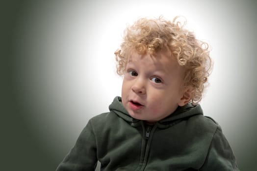 portrait of a little boy of 3 years with a green coat