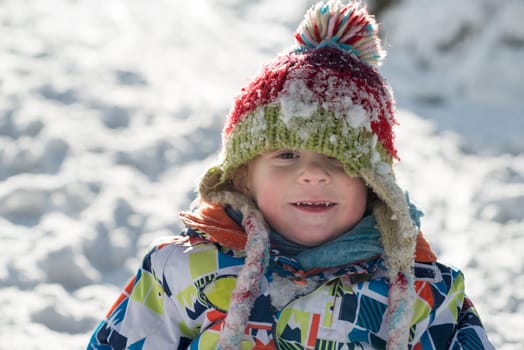 little 3 year old child playing in the snow