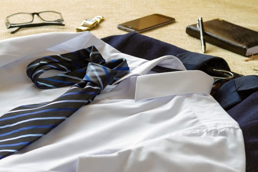 Business man clothes accessories and smartphone on bed. Business man preparing to go at office concept.