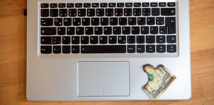 still life- computer keyboard with burned dollar bank notes