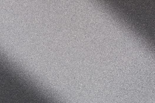 Granite background of gray color with small dots. Darkening left and right diagonally. Blurred.