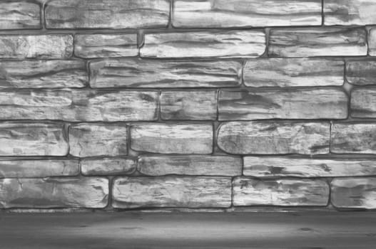 The wall is made of bricks of black and white color and wooden boards with a spot of illumination.