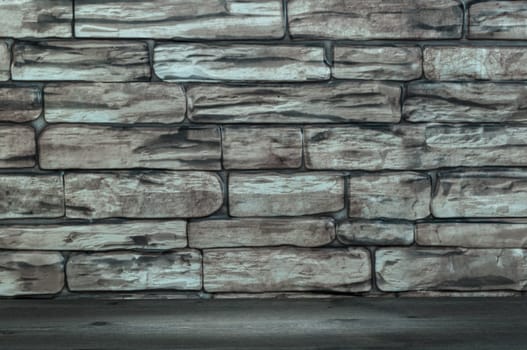 The wall is made of bricks and wooden boards with a spot of illumination.