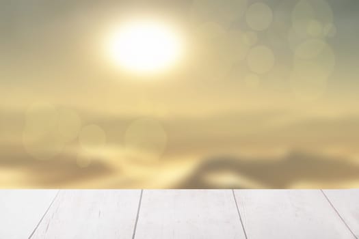 Table top and a blur abstract sunset and desert landscape background. Empty rustic wooden bright table top in front of abstract yellow desert landscape. Template for your product display montage.