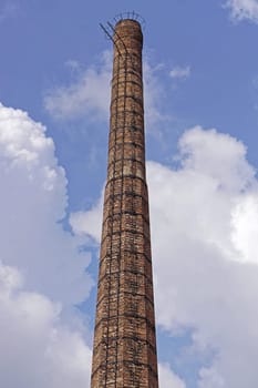 Old factory tall brick chimney with ladder