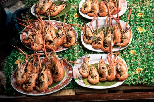 close up shot of grilled shrimps on plates in a row at street of Bangkok, Thailand