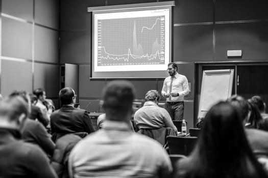 Public Speaker Giving a Talk at Business Meeting. Audience in the conference hall. Business and Entrepreneurship concept. Black and white image.