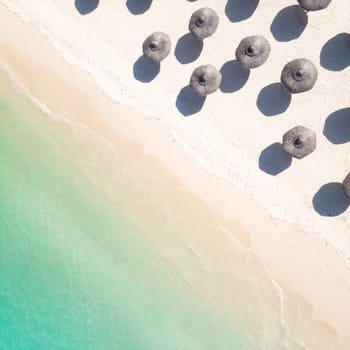 Aerial view of amazing tropical white sandy beach with palm leaves umbrellas and turquoise sea, Mauritius.