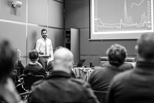 Public Speaker Giving a Talk at Business Meeting. Audience in the conference hall. Business and Entrepreneurship concept. Black and white image.