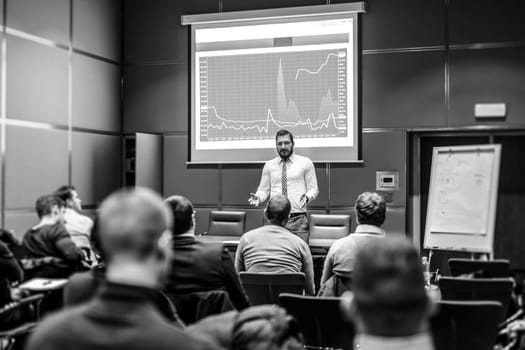 Public Speaker Giving a Talk at Business Meeting. Audience in the conference hall. Business and Entrepreneurship concept. Black and white image.