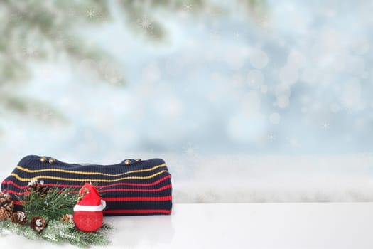 Autumn and winter children clothes. A red black striped cozy warm sweater or pullover with Christmas decorations over abstract winter landscape. Space for your design.
