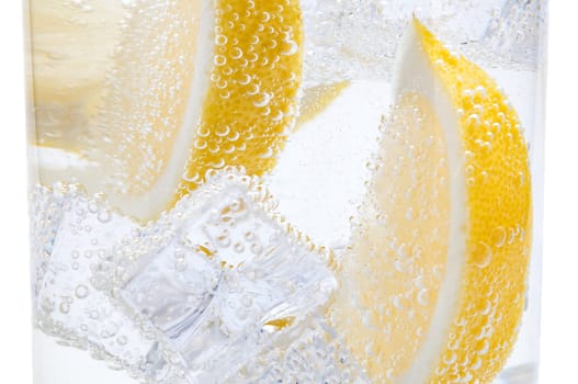 In a glass with cubes of melting ice slices of a juicy lemon.