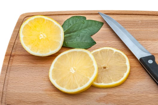 On the cutting board are a few slices of fresh lemon and a knife.