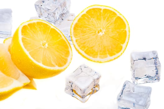 Cubes of cold ice, and halves of fresh, bright juicy lemon on a white background.