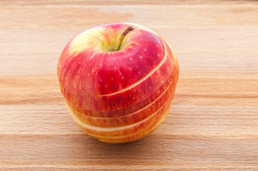 Red apple close-ups cut by mugs on a cutting board