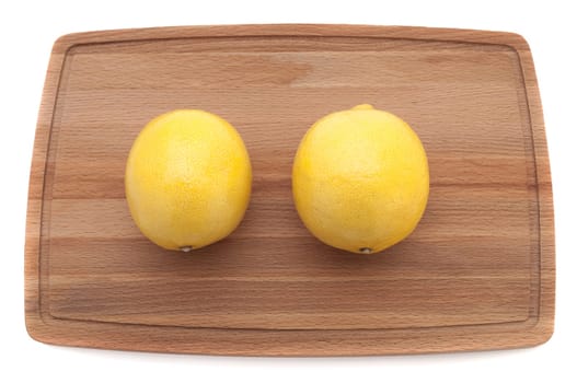 two yellow bright juicy lemon on a wooden board top view
