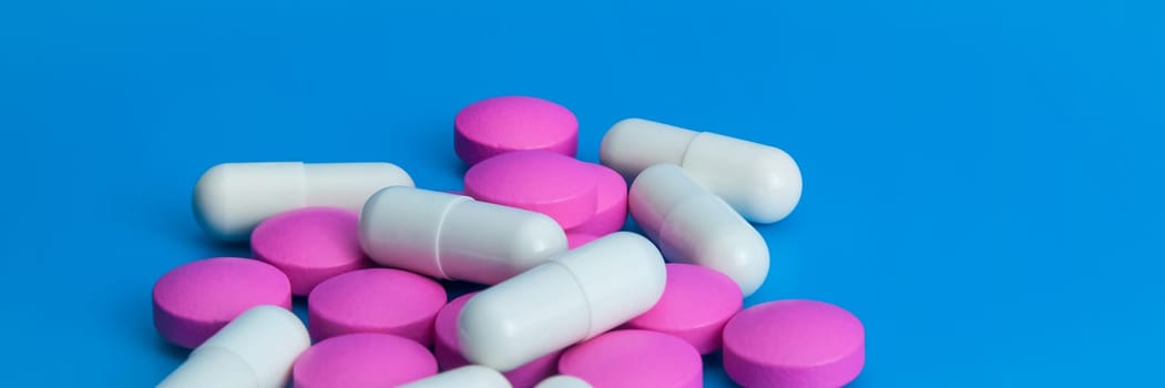A pile of large pills of pink and white color close-up.