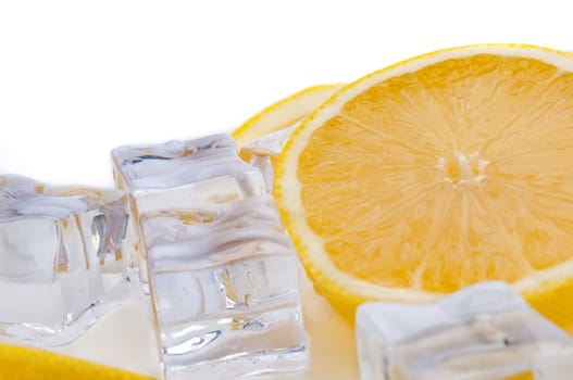 Half of juicy bright lemon and cubes of refreshing ice close-up on white background