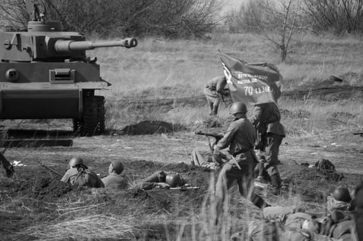 2018-04-30 The Samara Region, Russia. The offensive of soldiers of the Soviet army with a flag on the position of the German troops. Reconstruction of hostilities in April 1945.