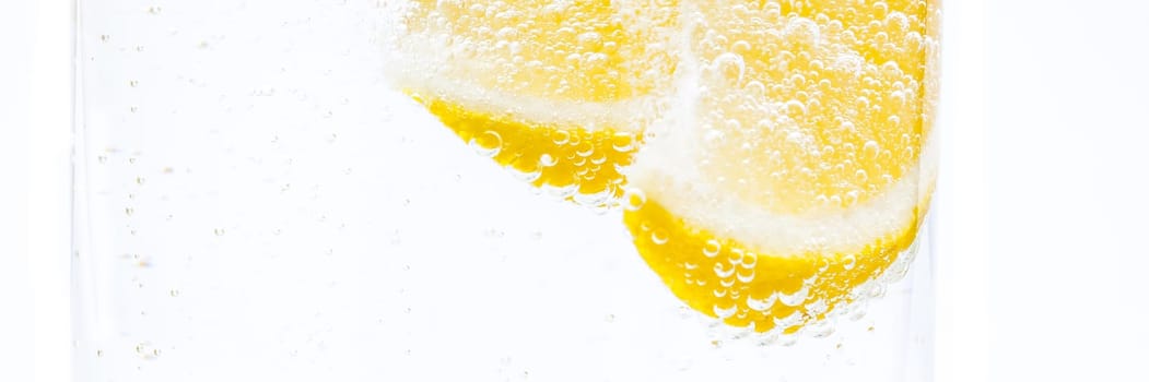 Two slices of fresh juicy lemon in lemonade.
