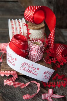 Cheerful ribbons for wrapping Christmas presents in front off wooden background