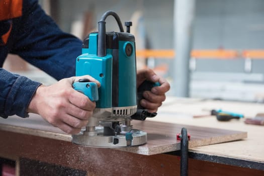 Furniture production or craft concept: worker polishing the wood surface of furniture part with polish machine