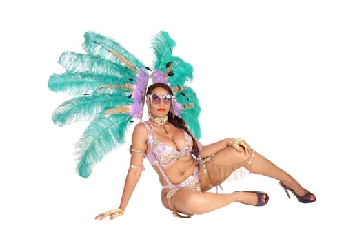 Beautiful woman sitting in colorful carnival costume in bra and panties.and green feather on her head, isolated for white background.