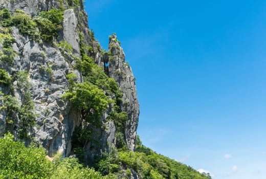 Stone or rock mountain or hill with green tree and blue sky and water and cloud at Khao Dang canal Prachuap Khiri Khan Thailand. Landscape or .scenery summer concept for boat trip