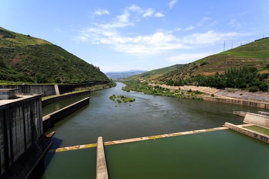 Downstream view of the Douro River from the top od the Regua Dam, all called Bagauste Dam, having the town of Peso da Regua at the end of the river view.