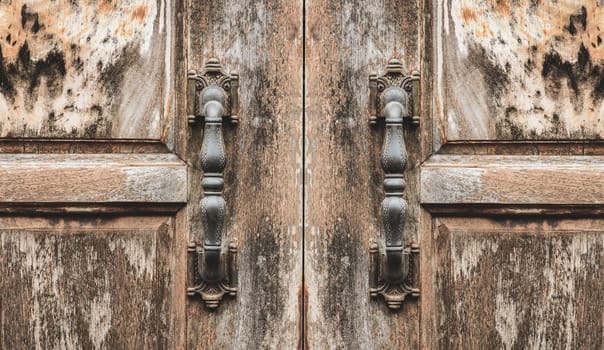 Antique door handle of grunge wooden door