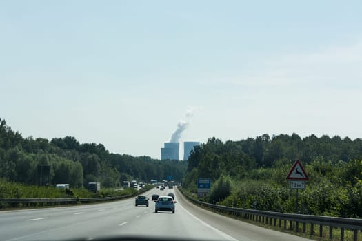 UNNA, GERMANY - AUGUST 23, 2017: Traffic on the A2 motorway and Scholven coal power station, Germany, North Rhine-Westphalia.