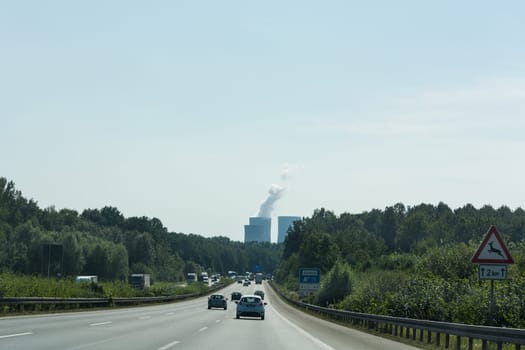 UNNA, GERMANY - AUGUST 23, 2017: Traffic on the A2 motorway and Scholven coal power station, Germany, North Rhine-Westphalia.