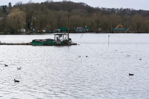 HEILIGENHAUS, NRW, DEUTSCHLAND - MÄRZ 03, 2017:.Special ship, working platform in use on a small pond. Wet dredging at the Abtskuecher Teich in Heiligenhaus.