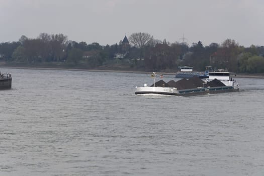DUESSELDORF, NRW, GERMANY - APRIL 02, 2017: .Schiff auf dem Rhein in der Nähe von Düsseldorf, Deutschland. Im Hindergrund das gegenüberliegende Ufer...DUESSELDORF, NRW, GERMANY - APRIL 02, 2017: .Ship on the Rhine near Dusseldorf, Germany. In the background the opposite shore..