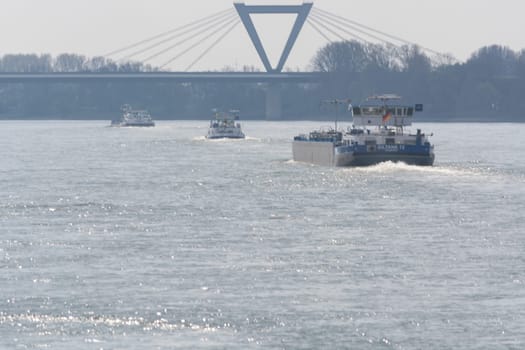 DUESSELDORF, NRW, GERMANY - APRIL 02, 2017: .Flusslandschaft vom Rhein, in der Nähe von Düsseldorf in Deutschland. Blick auf das gegenüberliegende Ufer und die Flughafenbrücke bei dramatischen Himmel. ..DUESSELDORF, NRW, GERMANY - APRIL 02, 2017: .River landscape from the Rhine, near Dusseldorf in Germany. View of the opposite bank and the airport bridge in dramatic sky.