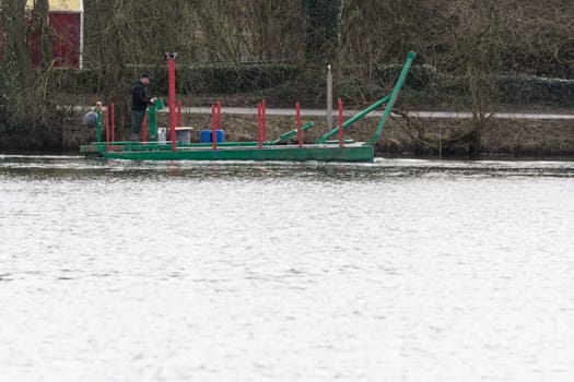 HEILIGENHAUS, NRW, DEUTSCHLAND - MÄRZ 03, 2017:.Special ship, working platform in use on a small pond. Wet dredging at the Abtskuecher Teich in Heiligenhaus.