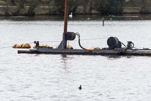 HEILIGENHAUS, NRW, DEUTSCHLAND - MÄRZ 03, 2017:.Special ship, working platform in use on a small pond. Wet dredging at the Abtskuecher Teich in Heiligenhaus.