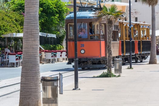PORT DE SOLLER, SPAIN - JUNE 02, 2016: Vintage train, tram on the beach promenade of the town of Soller in Spain. Opened in 1913, the driving distance is about 5 km long.