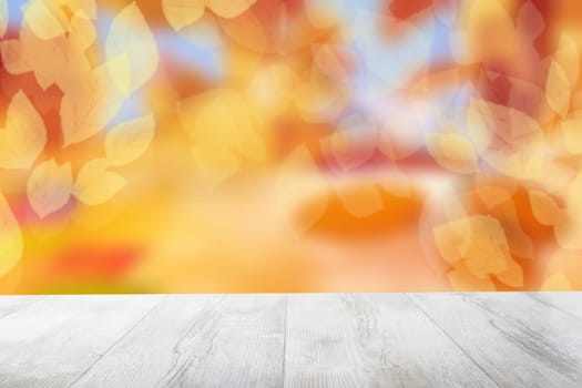 Empty table top autumn background. Empty rustic wooden bright table top in front of beautiful abstract golden autumn background. Template for product display montage. Space.