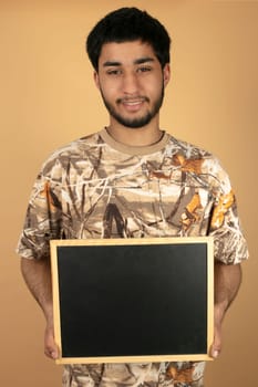 Young Man holding Blackboard on beige Background