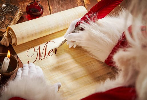Santa Claus handwriting a Christmas greeting on an old parchment scroll with a feather quill pen on a rustic table in a close up over the shoulder view of his hands