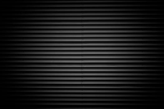 Wide shot of dark corrugated metal with bolts. Vignette added