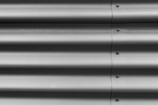 Detail of silver corrugated metal with bolts