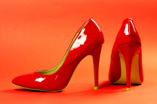 Sexy red high heels shoes are on red background.