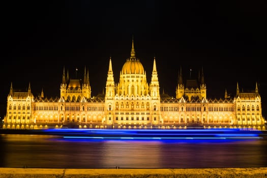 Landmark of Budapest Parliament at night on Danube with beautiful city lights.