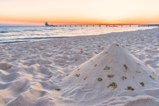 beach, drip castle, pier, bridge Zinnowitz in the sunrise, Baltic Sea island Usedom Germany