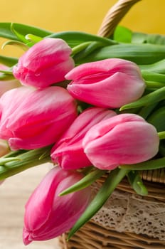 Beautiful bouquet of pink tulips in a wicker basket