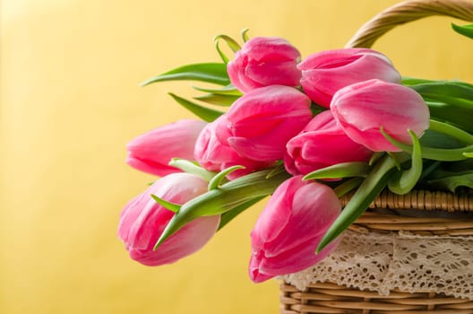 Beautiful bouquet of pink tulips in a wicker basket