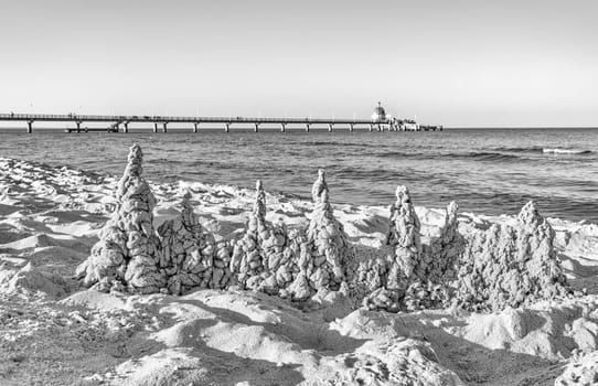 beach, drip castle, pier, bridge Zinnowitz in the sunrise, Baltic Sea island Usedom Germany- photographed in black and white