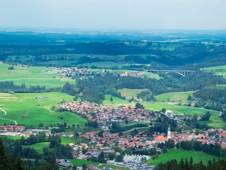 Landscape view on the town Nesselwang in Bavaria with the Wertachtalbrücke in the right background beri covered sky in summer 2018 photographed from the mountain station of the Alpspitzbahn.